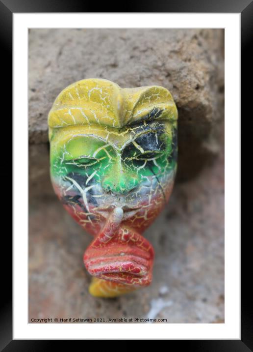 A Balinese mask puts a finger on mouth for secret  Framed Mounted Print by Hanif Setiawan