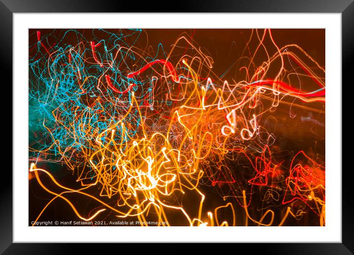 Abstract shapes of glowing swirled neon light Framed Mounted Print by Hanif Setiawan