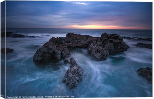 Ocean waves hit in a rock in a stormy day at the sunset. Canvas Print by nuno valadas