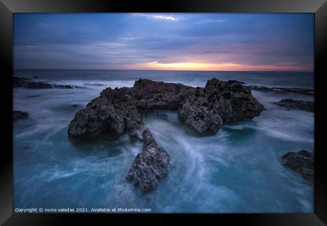 Ocean waves hit in a rock in a stormy day at the sunset. Framed Print by nuno valadas