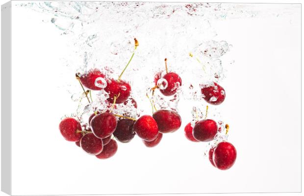 Red cherries splashing into crystal clear water with air bubbles. Isolated on a white background. Canvas Print by Przemek Iciak