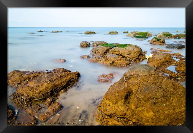 Rocks in the sea Framed Print by Clive Wells
