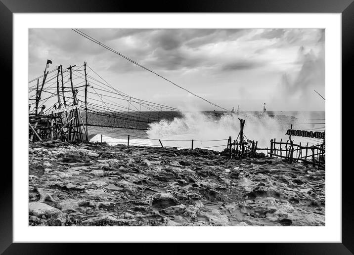 Big wave hits swinging rope foot bridge to island Framed Mounted Print by Hanif Setiawan