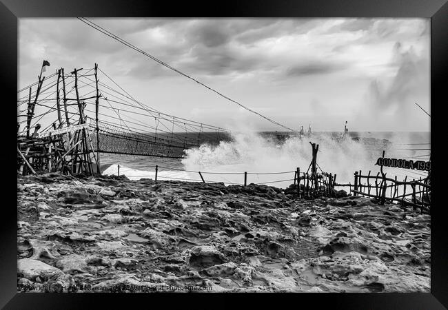 Big wave hits swinging rope foot bridge to island Framed Print by Hanif Setiawan
