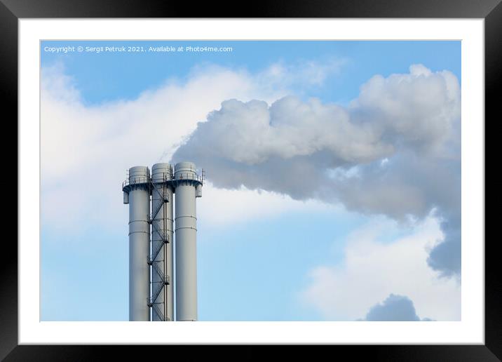 Emissions of smoke and steam from an industrial chimney into a clear sky. Framed Mounted Print by Sergii Petruk