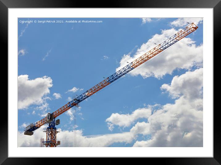 An arrow of a tower crane against a blue sky, divides the image diagonally. Framed Mounted Print by Sergii Petruk