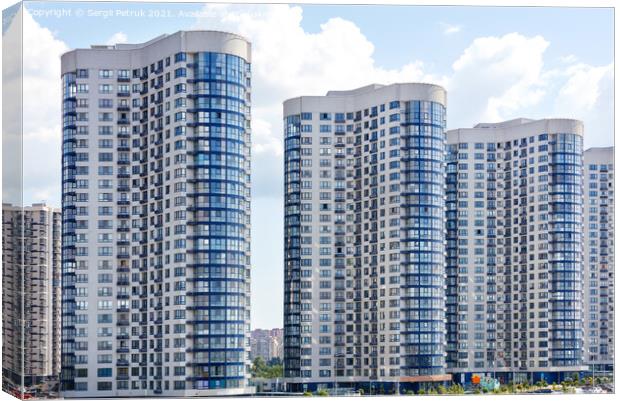 Tall houses of white-blue high-rise buildings in a new district of the city. Canvas Print by Sergii Petruk