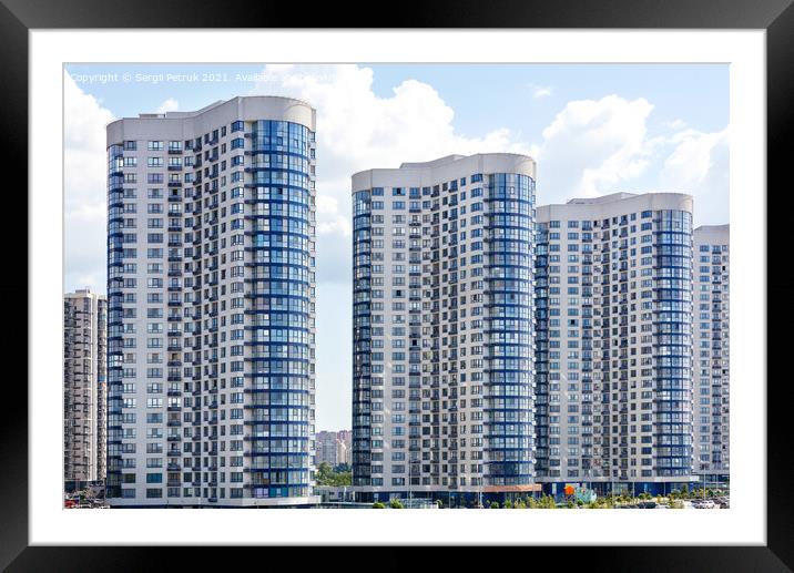 Tall houses of white-blue high-rise buildings in a new district of the city. Framed Mounted Print by Sergii Petruk