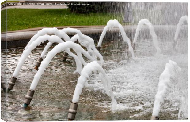 Foamed, dense jets of water burst from metal nozzles in the city fountain. Canvas Print by Sergii Petruk