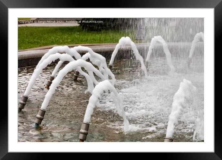 Foamed, dense jets of water burst from metal nozzles in the city fountain. Framed Mounted Print by Sergii Petruk