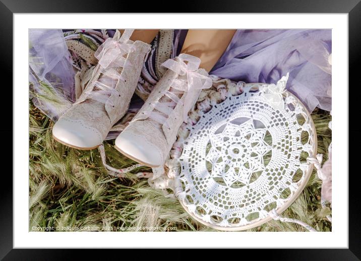 Boots on the feet of a girl who rests in the fresh grass next to Framed Mounted Print by Joaquin Corbalan