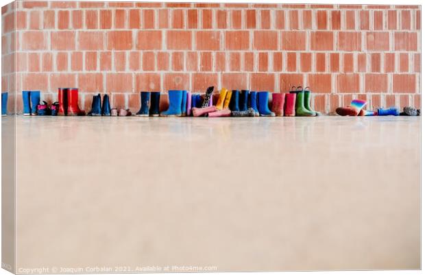 Rubber rain boots on the floor at the entrance to a college clas Canvas Print by Joaquin Corbalan