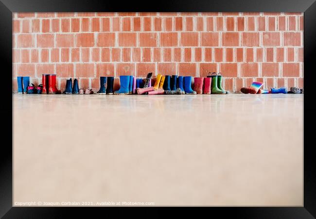 Rubber rain boots on the floor at the entrance to a college clas Framed Print by Joaquin Corbalan