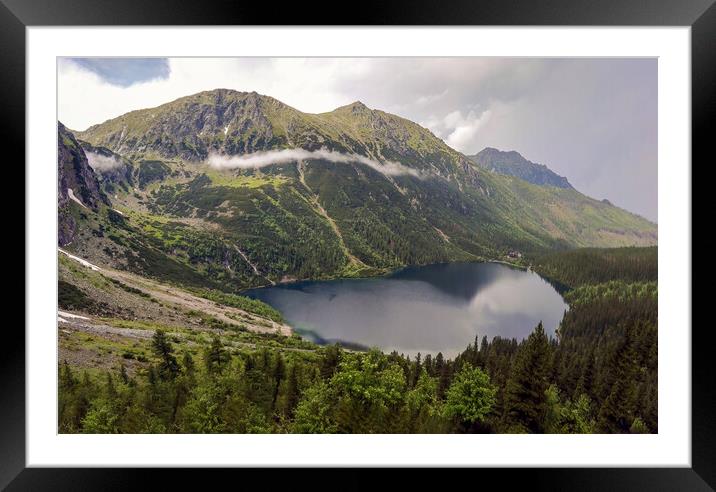 Wide angle top view of Morskie Oko naturally formed lake pond in Tatra Mountains in Poland. High mountain landscape with dramatic clouds covered with snow and trees at national park High Tatras Europe Framed Mounted Print by Arpan Bhatia