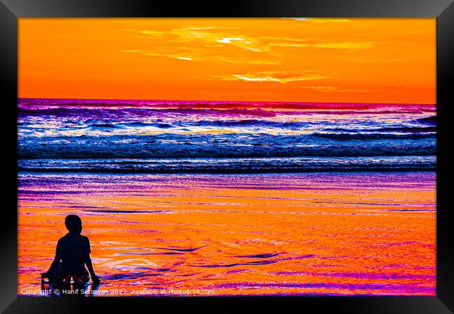 A young boy enjoys the sunset at a sand beach. Framed Print by Hanif Setiawan
