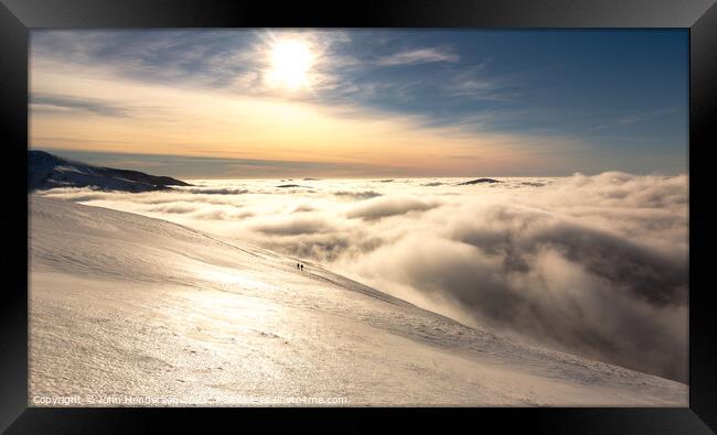 Winter walking Above the clouds Framed Print by John Henderson