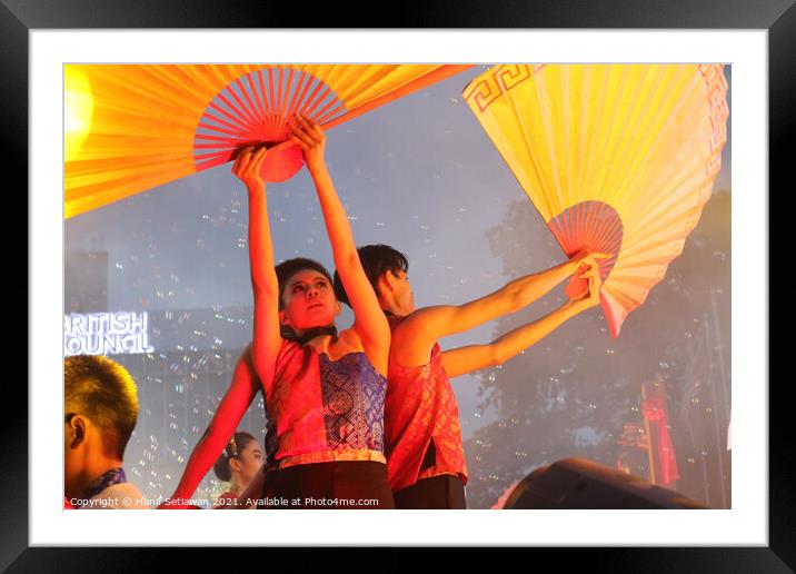 Dance performer raising arms with paper fans Framed Mounted Print by Hanif Setiawan
