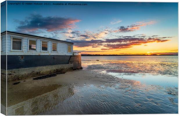 Sunset over an old boat on Bramble Bush Bay at Studland in Poole Canvas Print by Helen Hotson