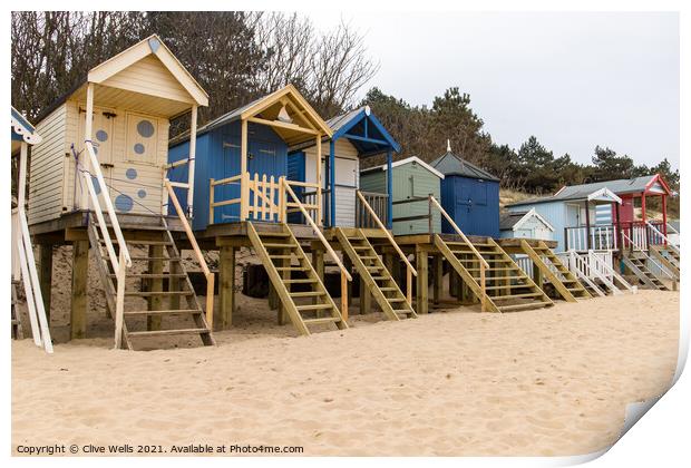 Beach huts above the sand Print by Clive Wells