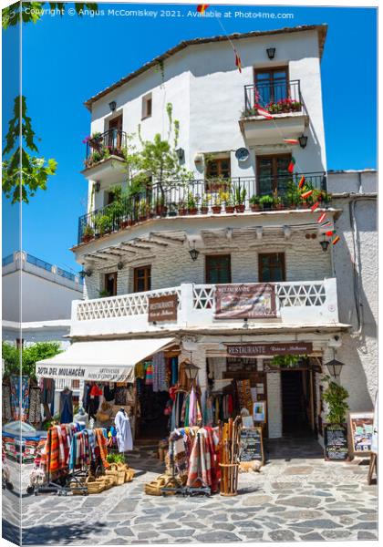 Apartment block and shop in Pampaneira, Spain Canvas Print by Angus McComiskey