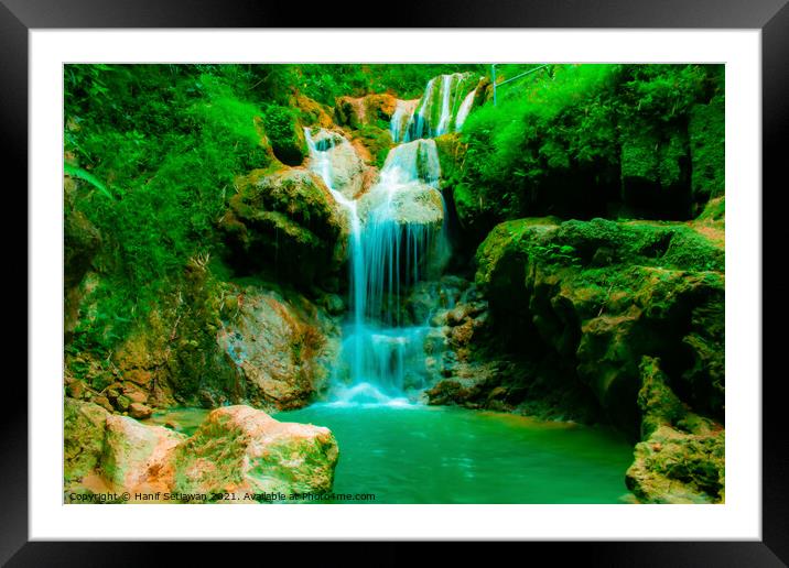 A waterfall flowing over rocks into a lake. Framed Mounted Print by Hanif Setiawan