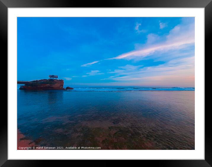 One rock on transparent sea water at Kukup beach. Framed Mounted Print by Hanif Setiawan