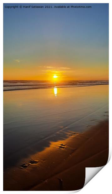 Wide sand beach reflecting orange sunset sunlight. Print by Hanif Setiawan