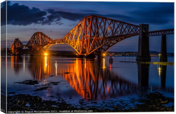 Floodlit Forth Rail Bridge at dusk Canvas Print by Angus McComiskey