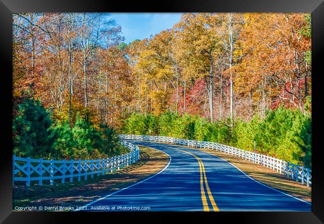 Road Curving Through Autumn Trees and White Fence Framed Print by Darryl Brooks