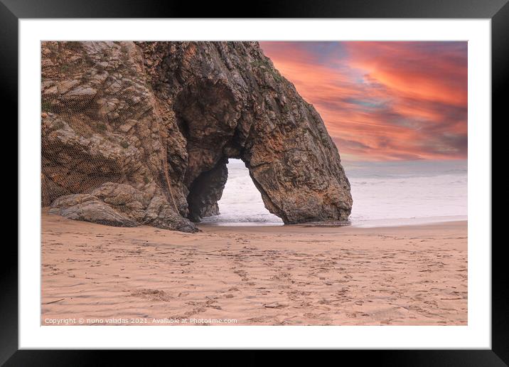 Beautiful stone natural arche. Rock formation in a beach with ocean in background at the sunset Framed Mounted Print by nuno valadas