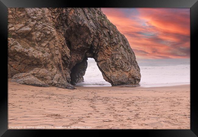 Beautiful stone natural arche. Rock formation in a beach with ocean in background at the sunset Framed Print by nuno valadas