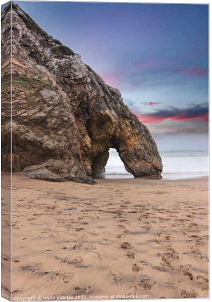 Beautiful stone natural arche. Rock formation in a beach with ocean in background at the sunset Canvas Print by nuno valadas