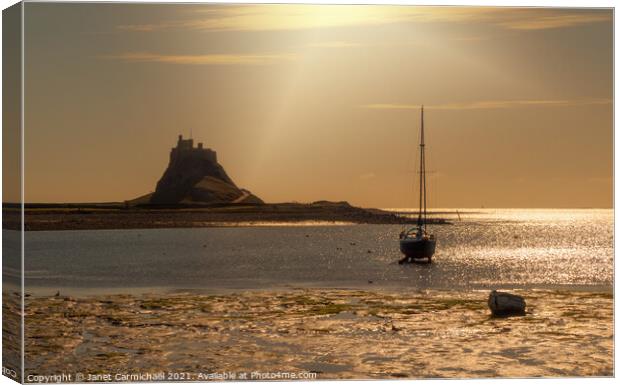 Sunrays on Lindisfarne Harbour and Castle Canvas Print by Janet Carmichael