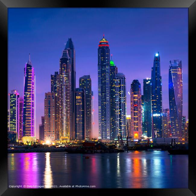 Dubai marina skyline illuminated at night, UAE Framed Print by Delphimages Art