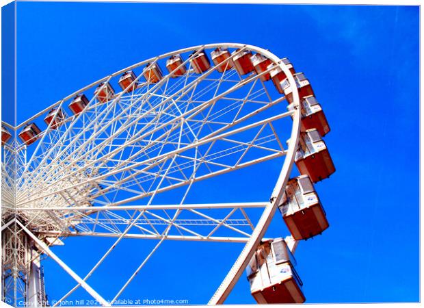 Ferris wheel against a blue sky. Canvas Print by john hill