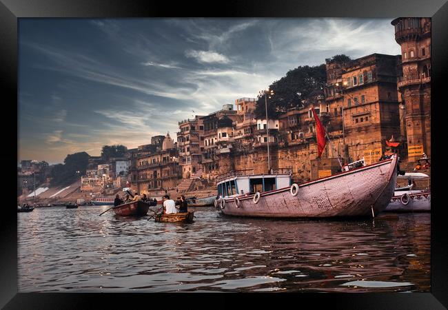 Varanasi, India: Dramatic sunset in a holy hindu place of worship with lots of tourists on boats and ancient architecture ghat located in Uttar pradesh. Framed Print by Arpan Bhatia