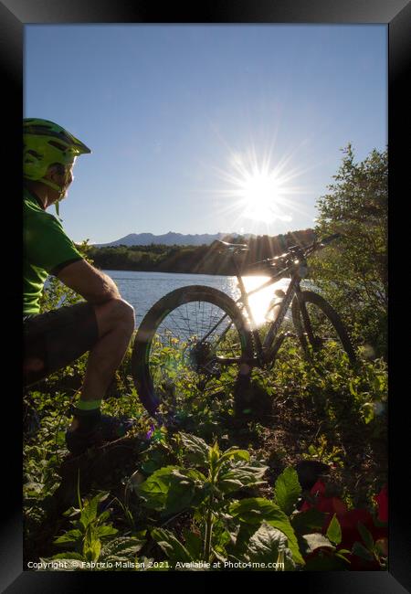 Mountain biking at sunset by the lake Framed Print by Fabrizio Malisan