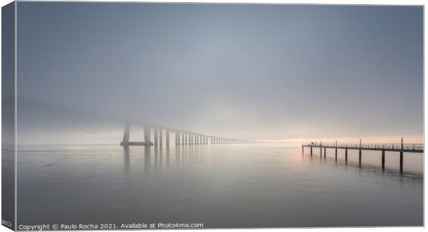 Long bridge over tagus river in Lisbon at sunrise with fog Canvas Print by Paulo Rocha