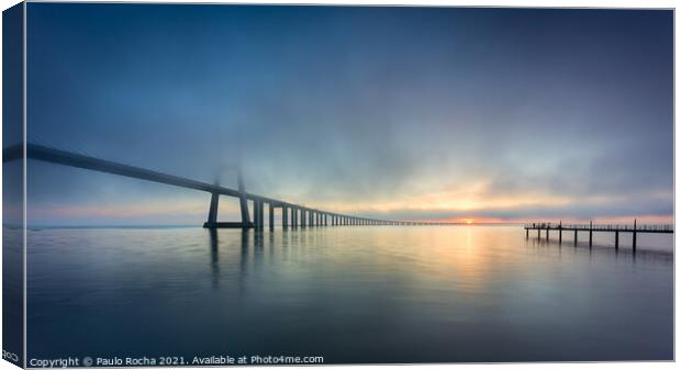 Long bridge over tagus river in Lisbon at sunrise with fog Canvas Print by Paulo Rocha