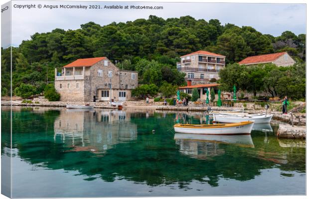 Colourful reflections in Pomena harbour, Croatia Canvas Print by Angus McComiskey