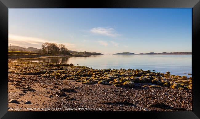Sunrise on a rocky beach at Kirkcudbright Bay, Dumfries and Galloway, Scotland Framed Print by SnapT Photography