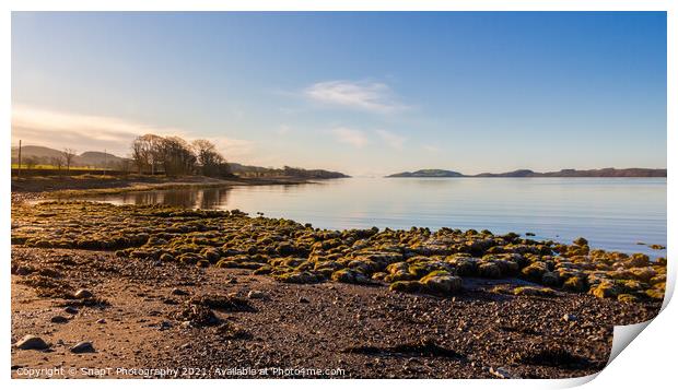 Sunrise on a rocky beach at Kirkcudbright Bay, Dumfries and Galloway, Scotland Print by SnapT Photography