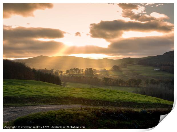 Sun rays over Scottish hills Print by christian maltby