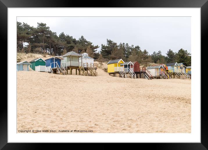Coloured beach huts on the sand dunes Framed Mounted Print by Clive Wells