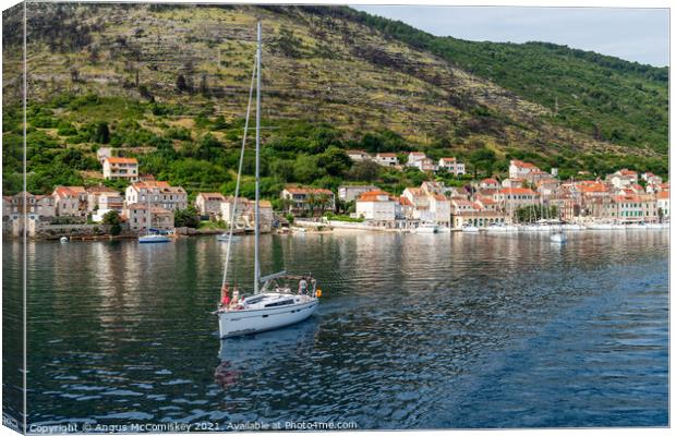 Yacht departing Vis Island, Croatia Canvas Print by Angus McComiskey