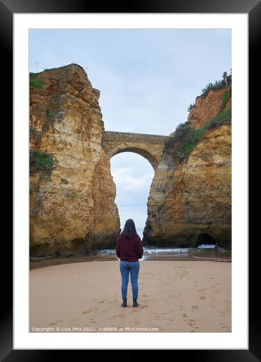 Woman traveler at Praia dos estudantes beach with arch bridge in Lagos, Portugal Framed Mounted Print by Luis Pina