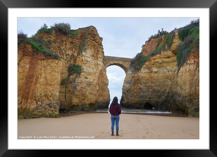 Woman traveler at Praia dos estudantes beach with arch bridge in Lagos, Portugal Framed Mounted Print by Luis Pina