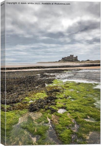 Bamburgh Castle at low tide Canvas Print by Kevin White