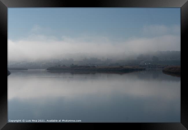 Fog river landscape at sunrise with low clouds and reflection on the water in Alcacer do Sal, Portugal Framed Print by Luis Pina