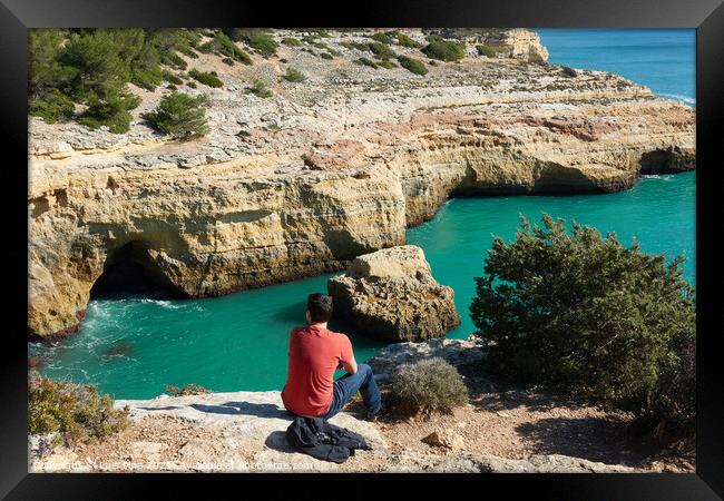 Man looking at a wild hidden secret beach with amazing turquoise water in Algarve, Portugal Framed Print by Luis Pina